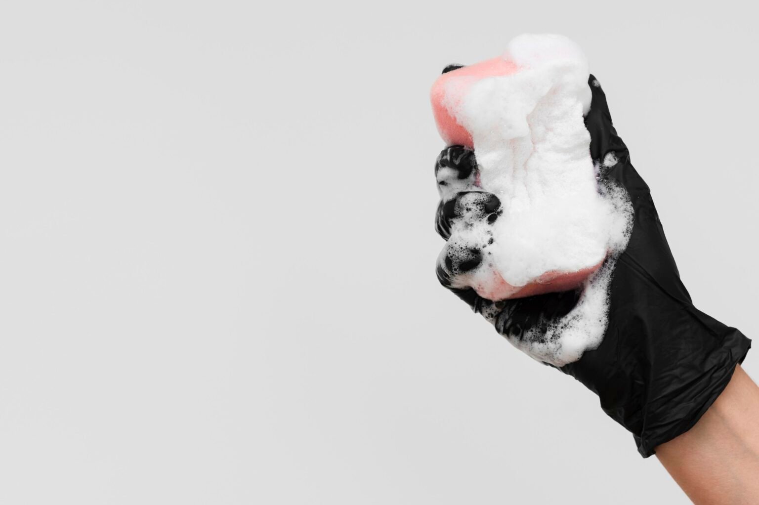 mano-con-guante-sosteniendo-esponja-con-espuma-y-ritmo-de-copia